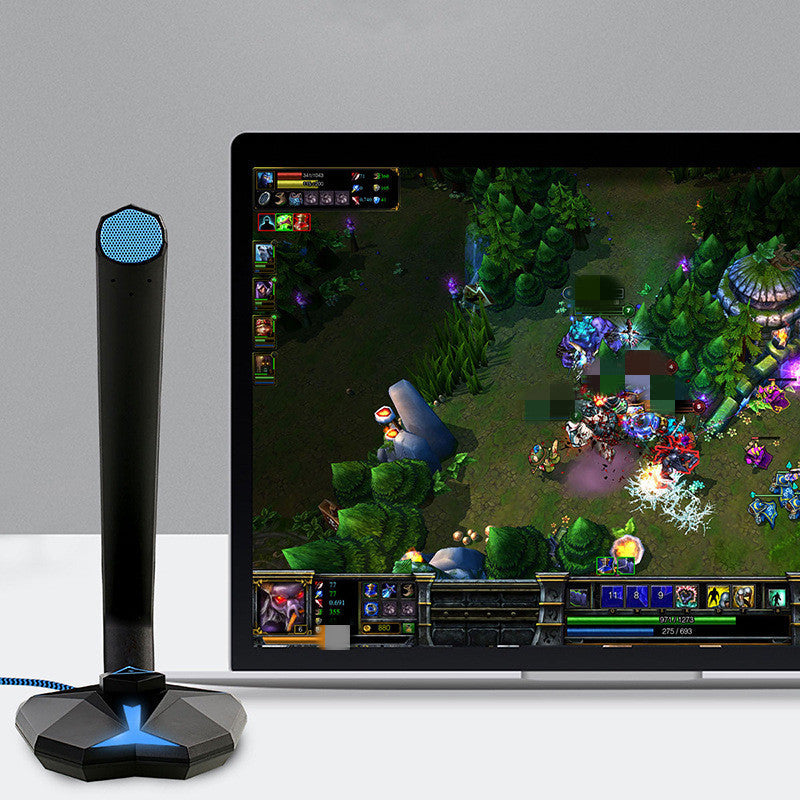 Gaming setup with a monitor displaying a game, a microphone, and a gray background.