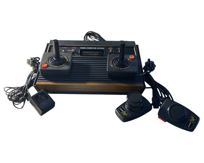 Vintage video game console with controllers on a white background