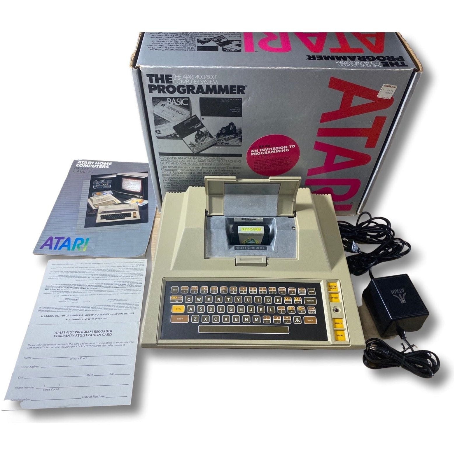 Vintage Atari computer with packaging and accessories on a white background