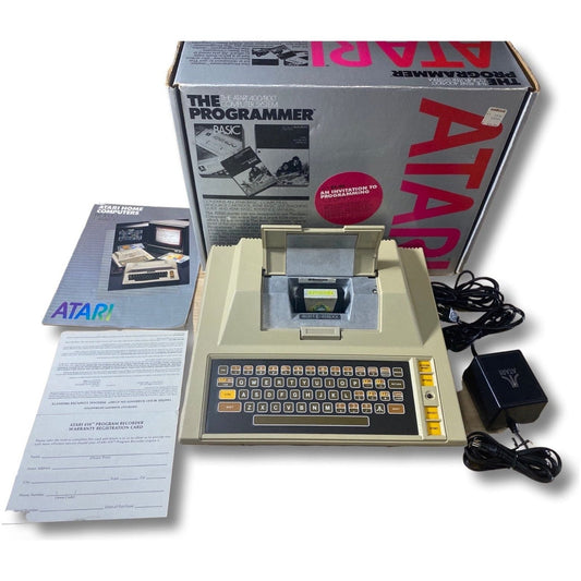 Vintage Atari computer with packaging and accessories on a white background