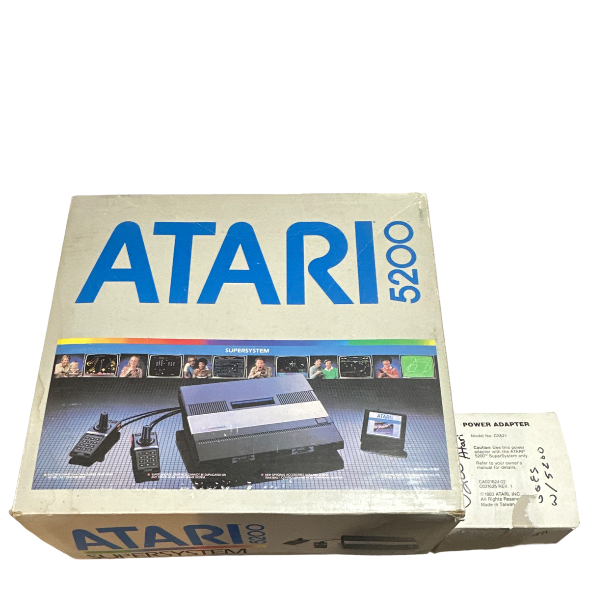 Vintage Atari 5200 Gaming Machine original retail box with console, two wired controllers, game cartridge, and power adapter displayed on a white background.