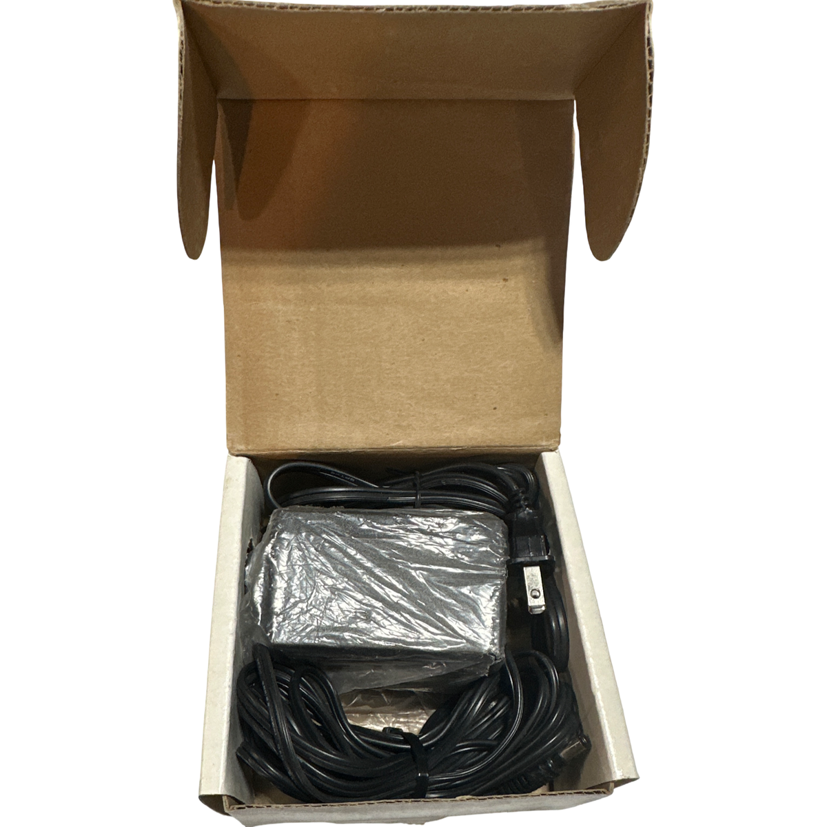 Open cardboard box containing the Atari 5200 AC power adapter with attached power cord, packaged as part of the Atari 5200 gaming console system bundle.