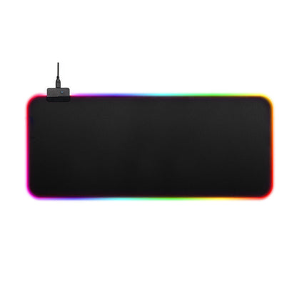 A large rectangular black desk mat or gaming pad with rounded corners, shown on a plain white background. A small black device with an antenna is attached near the top-left corner, and the mat is illuminated with a rainbow-colored LED border. Gaming Mouse Pad