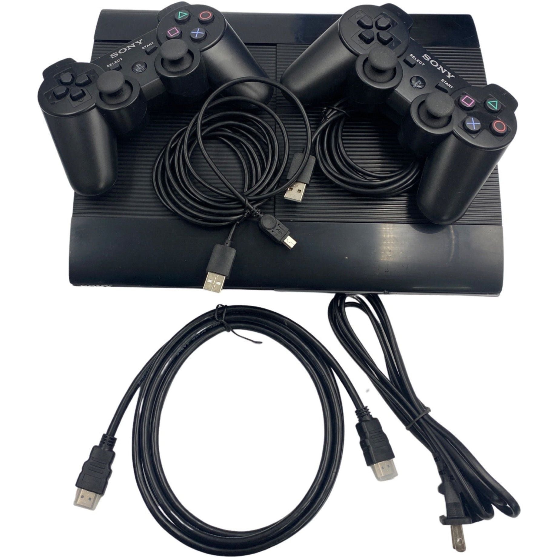 Black gaming console with controllers and cables on a white background