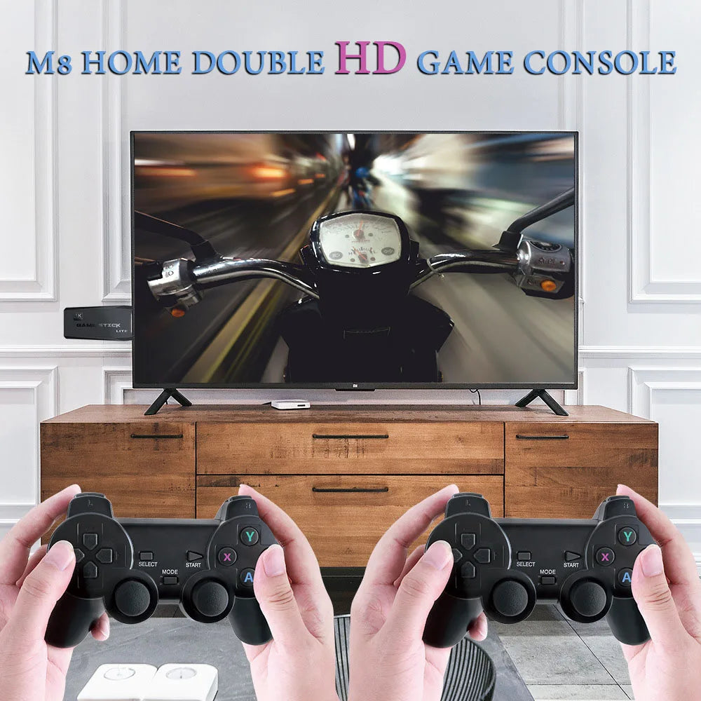 Two hands holding game controllers in front of a television displaying a racing game.
