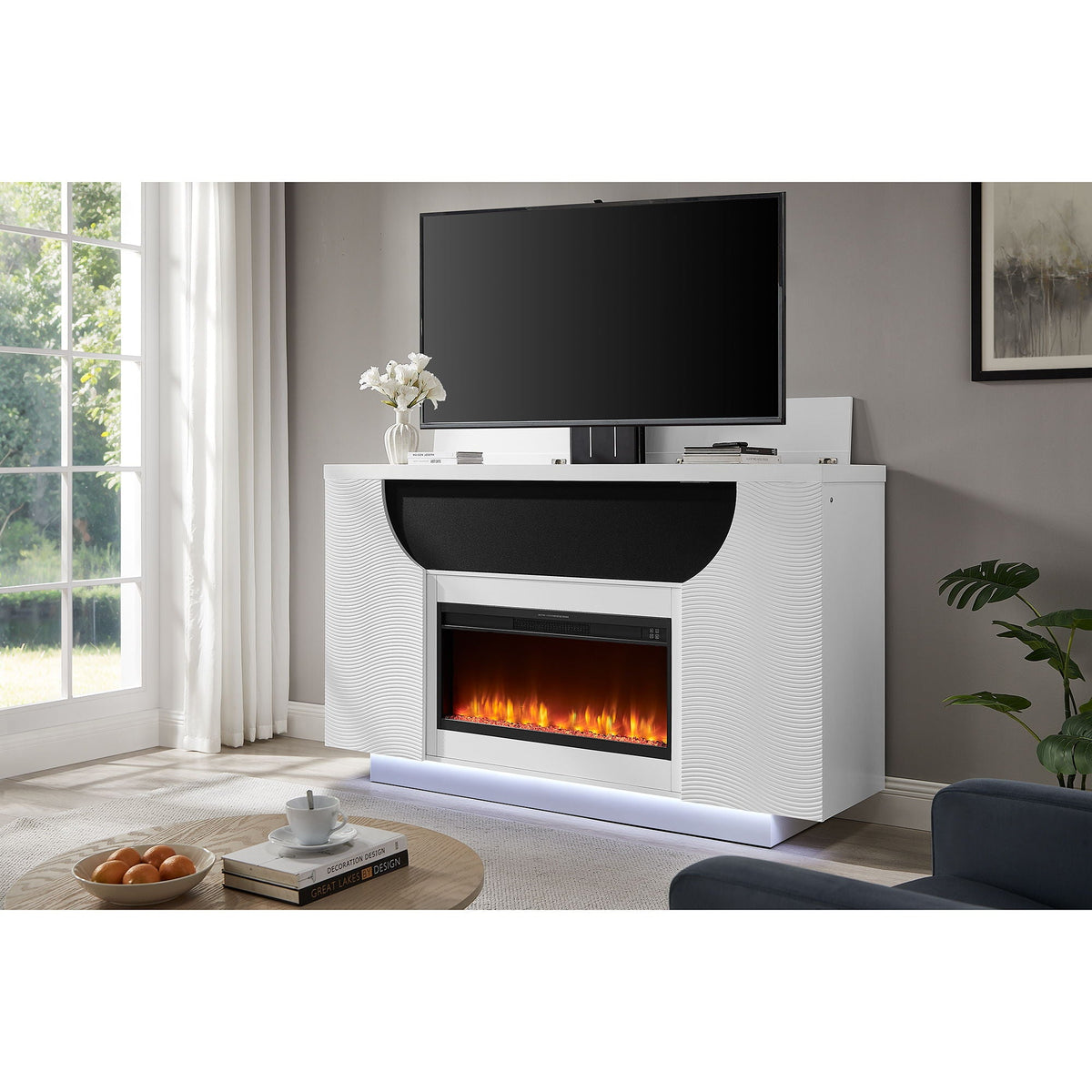 Modern living room with a white entertainment console featuring an electric fireplace, TV, and decor items.